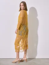 Kaftan largo color amarillo mostaza, de micro tul bordado con motivos florales. Tiene mangas largas y cordón ajustable en la cintura.