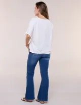 Remera blanca de manga corta, confeccionada en mezcla de modal, con diseño fluido y detalle de lazo ajustable en el lateral.