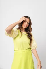 Blusa verde con cuello redondo y mangas cortas abullonadas.