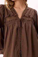 Blusa marrón con escote en V con lazo, mangas largas con elástico, detalle de bordados y puntillas.