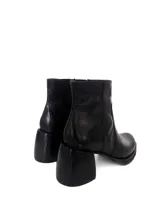 Bota corta de cuero negro con textura tipo reptil, taco cuadrado y plataforma. Cuenta con cierre lateral interno.