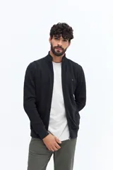 Campera de algodón color beige, estilo deportivo con cierre frontal, cuello alto y puños. Presenta bolsillos laterales y un pequeño logo bordado en el pecho.