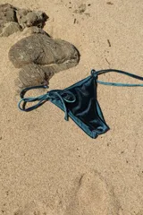 Bombacha de bikini color verde petróleo de terciopelo, con tiras laterales finas para atar.