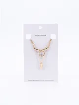 Collar de tres capas en tono dorado, compuesto por cadenas finas de eslabones. Presenta un diseño geométrico que incluye una barra curva, un círculo central y un dije en forma de cono o péndulo en la parte inferior.