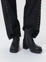 Bota de caña media Mutma modelo Minga, confeccionada en cuero color negro, con diseño acordonado, plataforma, taco ancho y punta cuadrada.