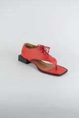 Sandalias de cuero color beige con diseño de ojota acordonada en el empeine, puntera cuadrada y taco bajo cuadrado.