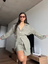 Short verde con finas rayas verticales blancas, de tela sastrera sin elasticidad.