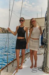 Minifalda negra tejida a crochet con cintura baja y cordón ajustable.