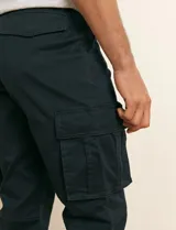 Pantalón cargo color verde militar, de corte recto, con bolsillos laterales con fuelle, bolsillos delanteros inclinados y bolsillos traseros.