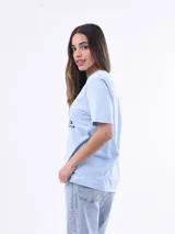 Remera blanca de manga corta con estampado frontal de una tortuga marina rodeada de corales y la frase "OCEAN LIFE".