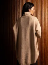 Polerón negro de tejido de punto con cuello alto, diseño oversized, mangas 3/4 y corte asimétrico más largo en la parte posterior.