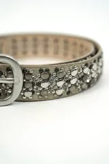 Cinturón de cuero sintético dorado con apliques de tachas y strass plateados, hebilla metálica plateada.