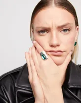 Anillo plateado con un cristal verde esmeralda rectangular.