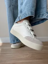 Zapatillas blancas de cuero con detalles en cuero gamuzado color beige en la puntera y ajuste con velcro. Presenta detalle de cuero con estampado reptil en el talón.