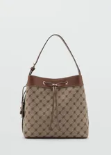 Bolso tipo bucket de poliéster y poliuretano, con diseño estampado geométrico en tonos marrón y beige, detalles en cuero sintético marrón, cierre de cordón ajustable y asa de hombro.