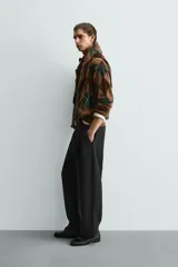Polo de punto de corte relajado, con estampado de rombos en tonos marrón y verde. Presenta cuello solapa con abertura frontal, manga larga y acabados en rib.