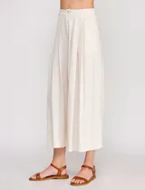 Pantalón palazzo de lino y viscosa, color blanco, de tiro alto y silueta amplia. Presenta pinzas frontales, bolsillos laterales y cierre con botón.