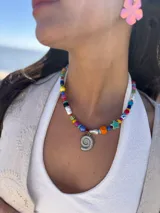 Collar corto con cuentas de colores y dije de caracol en acero quirúrgico.