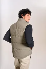 Chaleco puffer de corte regular, color beige, con cuello alto, cierre frontal completo y logo bordado en el pecho.