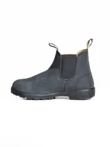 Bota tipo Chelsea de cuero color gris oscuro, con elásticos laterales negros y suela de goma dentada. Presenta tiradores en la parte superior para facilitar el calce.