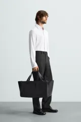 Camisa de manga larga color celeste claro, corte slim fit, con cuello italiano abierto y cierre frontal de botonadura.