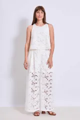Pantalón palazzo blanco de broderie con cintura alta y pierna ancha.