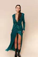 Vestido largo de lentejuelas color negro, con escote profundo en V, mangas largas y tajo lateral en la falda. Presenta un diseño cruzado con fruncido en la cintura y espalda elastizada.