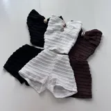 Conjunto de dos piezas color marrón, compuesto por un top strapless con frunces y detalle de hebilla metálica en el centro, y un short ajustado con diseño fruncido en los laterales.