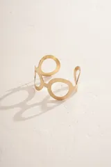 Brazalete dorado con diseño de círculos y textura martillada.