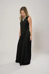 Pantalón negro súper campana de tiro medio en lino con bordados, con bolsillos delanteros y en la espalda. Cierre frontal con cremallera y botón.