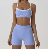 Conjunto deportivo compuesto por un top de breteles finos con ribetes blancos y un short de tiro alto con costuras laterales en contraste.