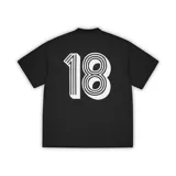 Camiseta de fútbol de manga corta en color negro, con cuello en V. Presenta el logo de la marca Corteiz en el pecho, junto a un escudo con los colores de la bandera italiana y una estrella dorada. El nombre de la marca aparece estampado en grande en el centro del frente.