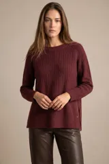 Sweater de punto con textura acanalada, cuello redondo y mangas largas. Presenta un diseño de calce holgado con ruedo redondeado y aberturas laterales.