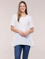 Blusa blanca de tejido de punto liviano con textura labrada en franjas verticales y caladas, de silueta evasé, con escote redondo, manga corta y ruedo asimétrico en picos.