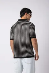 Chomba de punto con diseño de rayas verticales en color negro y blanco, cuello polo y manga corta con terminación acanalada.