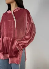 Canguro oversize de plush rosa viejo, con capucha ajustable, mangas globo, bolsillo tipo canguro y tajos laterales con tiras ajustables.