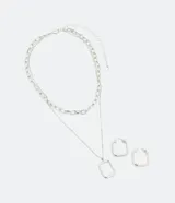 Conjunto de aros rectangulares plateados y collar a capas con cadena de eslabones cortos y cadena fina con colgante rectangular.