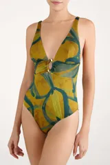 Malla enteriza estampada en tonos mostaza y verde oscuro, con escote en V profundo y detalle de argolla metálica en el centro del pecho.