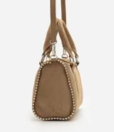 Cartera satchel de gamuza sintética color marrón, con diseño estructurado, doble asa de mano y tachas decorativas en los bordes. Cuenta con cierre superior y herrajes plateados.