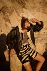 Campera de cuero oversize con solapa amplia de corderito, mangas anchas y detalle de cuero trenzado en la parte delantera.