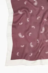 Pañuelo cuadrado de tejido suave, color bordó con estampado paisley en blanco y borde blanco.