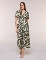 Enterito verde oscuro con estampado floral y abstracto en tono beige, de corte suelto y caída fluida. Presenta escote en V, mangas cortas, cintura elastizada con faja fruncida y pantalón crop de pierna ancha con bolsillos laterales.