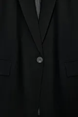 Blazer de cuello solapa y manga larga, con bolsillos delanteros con solapa y cierre frontal de un botón. Presenta un diseño estructurado con forro interior.