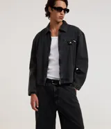 Pantalón de jean azul oscuro de corte super baggy, con diseño holgado, tiro medio y efecto marmoleado. Cuenta con bolsillos laterales y trabillas para cinturón.