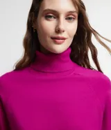 Blusa de punto color verde, con cuello alto y manga larga. Diseño básico y ajustado al cuerpo.