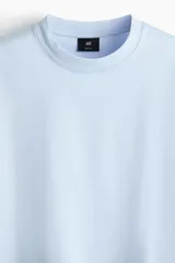 Remera de corte relajado, color celeste, de manga corta y cuello redondo.