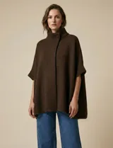 Poncho tejido de punto color marrón oscuro, con cuello alto abotonado y mangas cortas tipo japonesa.