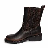 Bota de caña media confeccionada en cuero vacuno con efecto desgastado. Presenta elásticos laterales para un calce cómodo, taco de madera y suela de caucho.