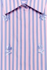 Camisa de cuello solapa y mangas cortas abullonadas, con diseño de rayas verticales en tonos rosados y celestes, decorada con lentejuelas bordadas.