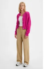 Pantalón de corte baggy en color beige, con diseño de tiro medio y pernera ancha. Presenta cierre frontal con botón y cremallera, y bolsillos laterales.